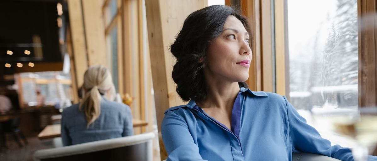woman sitting down, looking out window